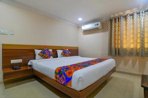 um quarto com uma cama grande num quarto em FabHotel Pishori em Indore