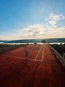 une personne jouant au tennis sur un court de tennis dans l'établissement UMVA Muhazi, à Muhazi