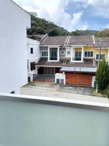 two views of a house with a garage at Azzalea Homes 2 @ Taman Golden Hills Cameron Highlands in Cameron Highlands