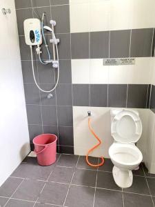 a bathroom with a shower and a toilet and a bucket at Azzalea Homes 2 @ Taman Golden Hills Cameron Highlands in Cameron Highlands