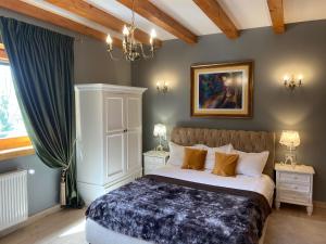 a bedroom with a bed and a painting on the wall at Carpathian Log Home in Bran