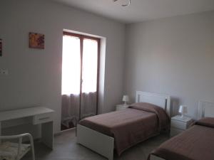 1 dormitorio con 2 camas y ventana en Anagnina Apartment Capistrano en Roma