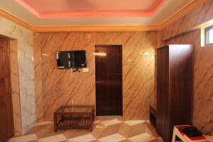 a room with a wooden wall with a tv and a table at French Breeze Residency in Puducherry