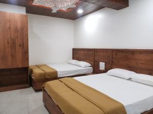 - une chambre avec 2 lits et un mur dans l'établissement Mahalaxmi Executive, à Kolhapur