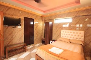 um quarto com uma cama e uma televisão de ecrã plano em French Breeze Residency em Pondicherry