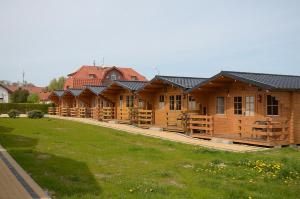 a row of wooden lodges in a park at ARKA Centrum Rekreacji Wypoczynku i Rehabilitacji in Jarosławiec