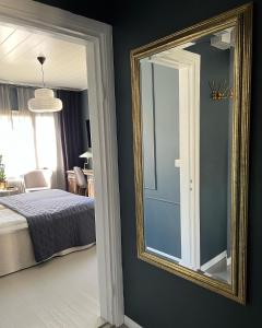 a mirror in a bedroom with a bed and a chair at The Bird Cherry Junior Suite in Varkaus