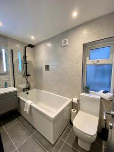 a bathroom with a tub and a toilet and a sink at Eden Retreats Serviced Apartments in Morecambe