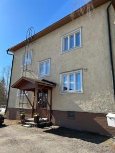 um edifício com um alpendre e janelas em The Bird Cherry Junior Suite em Varkaus
