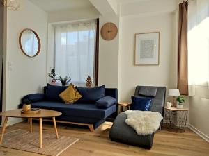 Una sala de estar con un sofá azul y una mesa. en NOUVEAU*Le Bois étoilé*Balnéo*Massage*Détente*Wifi*Netflix*Self-checkin, en Venette