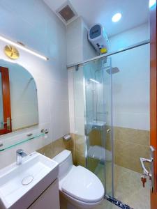 uma casa de banho com um WC e uma cabina de duche em vidro. em Upla Homestay em Vung Tau