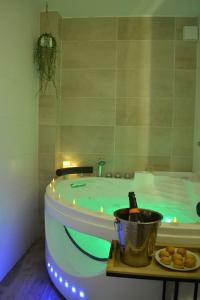 a bathroom with a green tub and a bucket of fruit at NOUVEAU*Le Bois étoilé*Balnéo*Massage*Détente*Wifi*Netflix*Self-checkin in Venette