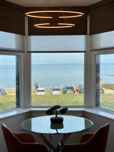 a table in front of a window with a tree on it at Eden Retreats Serviced Apartments in Morecambe