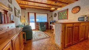 a living room with a kitchen and a living room with a couch at Eugenia - Maison dOc in Bardonecchia