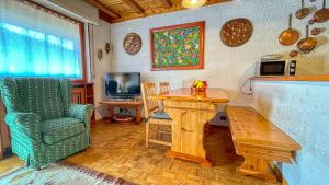 a living room with a table and a chair at Appartamento Eugenia - Affitti Brevi Italia in Bardonecchia