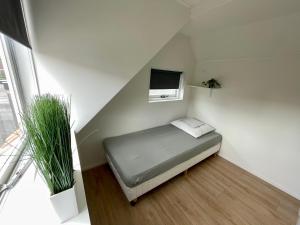 Habitación pequeña con cama y TV. en T-Rots, prachtig zomerhuis en Noordwijk aan Zee