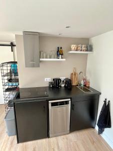 a kitchen with a black counter top and a dishwasher at T-Rots, prachtig zomerhuis in Noordwijk aan Zee