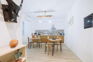 una cucina con tavolo e sedie in una stanza di Domo Amsicora - Affittacamere - By Faendho a Porto Torres