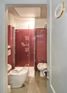 een badkamer met een douche, een toilet en een wastafel bij City Hotel in Viareggio