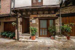 a building with potted plants sitting outside of it at CASA Apartamento RURAL AS ANDURIÑAS in San Martín de Trevejo