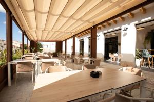 a restaurant with tables and chairs on a patio at La Posada de Consuelito in Chiloeches