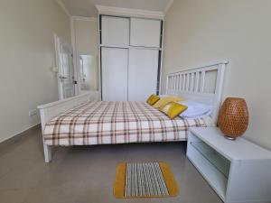 a bedroom with a bed with yellow pillows and a rug at Funchal Centre Comfort in Funchal