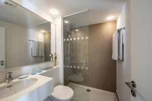 a bathroom with a sink and a toilet and a shower at Aliathon Aegean in Paphos City