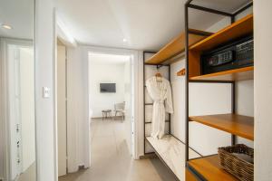 a walk in closet with a white robe on a rack at Aliathon Aegean in Paphos City