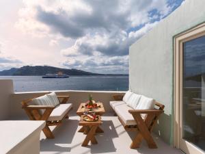 uma varanda com cadeiras e vista para a água em Secret Gem Suites em Oia