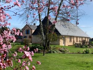 ein Haus mit einem blühenden Baum davor in der Unterkunft Les Logis du Breuil in Marchéville