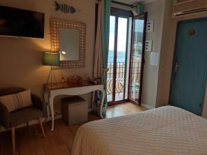 1 dormitorio con cama, escritorio y ventana en Hotel Cap d'Or, en Tossa de Mar