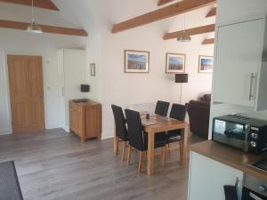 a living room with a wooden table and chairs at Greenacres in Kelsale