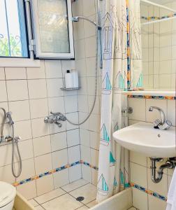a bathroom with a shower curtain and a sink at Lemnos Retreat Villa-250m from the Beach 1km from Diapori in Kondiás