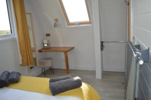 ein Schlafzimmer mit einem Bett mit einer gelben Decke und einem Schreibtisch in der Unterkunft Saddle Hill Lodge in Broome
