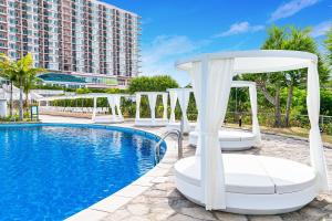 a hotel swimming pool with chairs and a hotel at Oriental Hotel Okinawa Resort & Spa in Nago