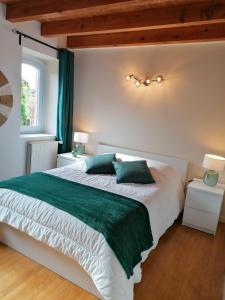 La maison d'Hôtes Du Moulin في Lagardelle-sur-Lèze: غرفة نوم بسرير كبير وملاءات خضراء وبيضاء