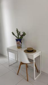 d'une table blanche et d'une chaise avec un vase. dans l'établissement Villa Caponegro, à Avola