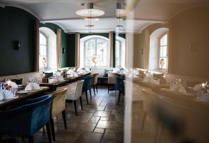 a dining room with tables and chairs and windows at Seehotel Luitpold in Tegernsee
