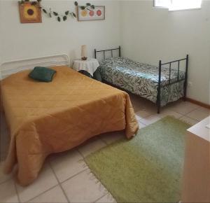 a bedroom with two beds and two rugs at CASA do MONDEGO COIMBRA-17km in Penacova