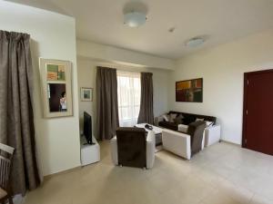 a living room with a couch and a television at 1 Bedroom in Jumeirah Beach Residence Dubai in Dubai