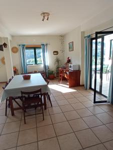 ein Wohnzimmer mit einem Tisch und einer Küche in der Unterkunft CASA do MONDEGO COIMBRA-17km in Penacova