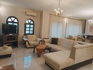 a living room with a couch and a tv at Sunny Loft in Kavála