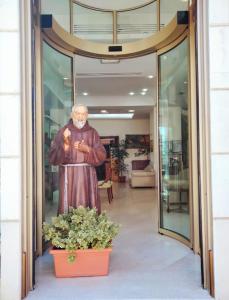 une statue d'un homme debout à l'extérieur d'un bâtiment dans l'établissement HOTEL PACE, à San Giovanni Rotondo