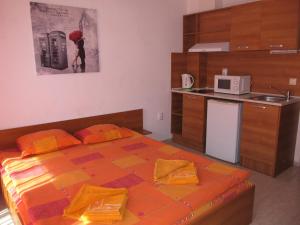 a small bedroom with a bed and a microwave at Apartments and studios in Cote d’Azure in Sunny Beach