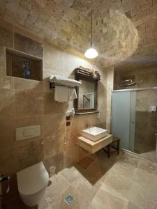 a bathroom with a sink and a toilet and a mirror at Sofa Hotel in Avanos