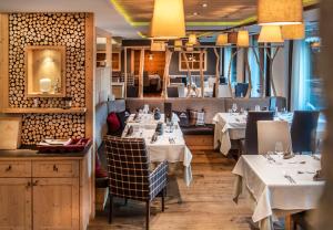 a restaurant with tables with white tablecloths at ABINEA Dolomiti Romantic SPA in Castelrotto
