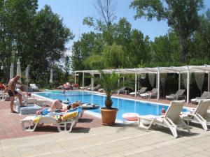 a group of people laying on lounge chairs by a pool at Apartments and studios in Cote d’Azure in Sunny Beach