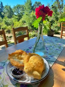 a table with a plate of food and a vase with flowers at Sirena Holiday Park in Kamchia