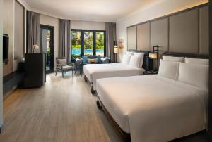 a hotel room with two beds and a sitting area at InterContinental Pattaya Resort, an IHG Hotel - SHA Extra Plus in Pattaya South