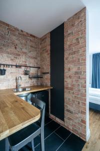 a kitchen with a brick wall and a wooden table at W Starym Porcie - Apartament - 2 sypialnie in Krynica Morska
